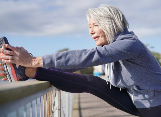 una donna anziana allunga la flessibilità, invecchia più velocemente
