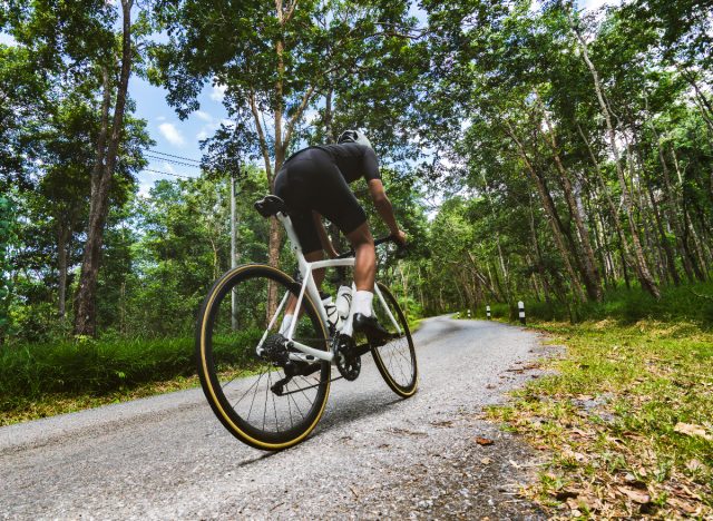 cyclist climbing uphill workout to lose belly fat in a week
