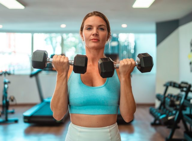 kvinna gör dumbbell curls för att gå ner i vikt på en vecka