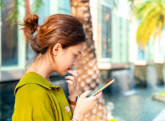 woman looking pensive at her phone