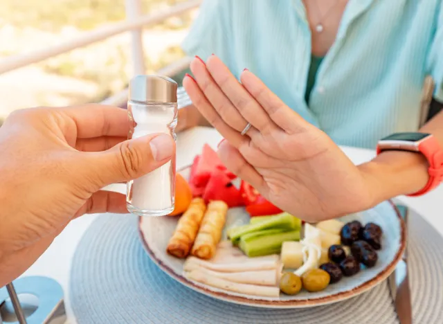 woman refusing salt shaker