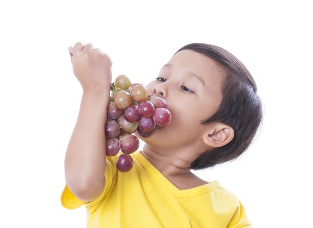 Kid eating grapes