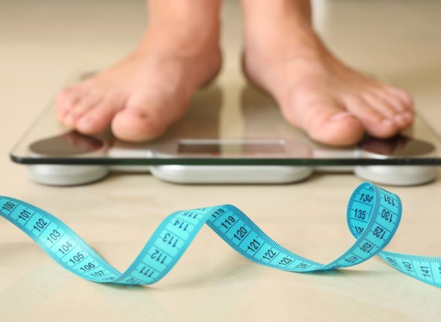 close-up feet on scale taking weight, common workout myths