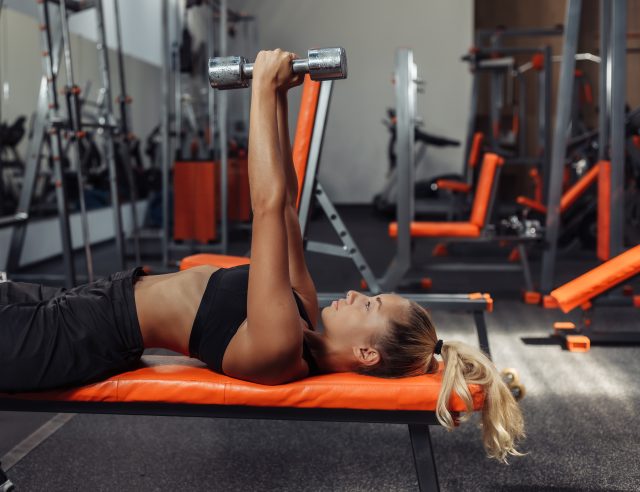 woman doing dumbbell tricep extension