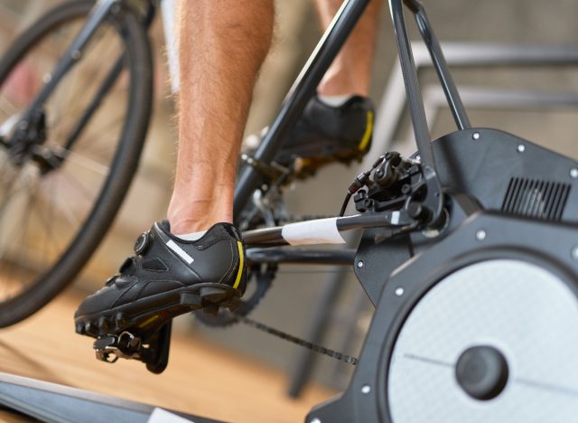 close-up man on exercise bike, demonstrating tricks for getting a fitter body after 50