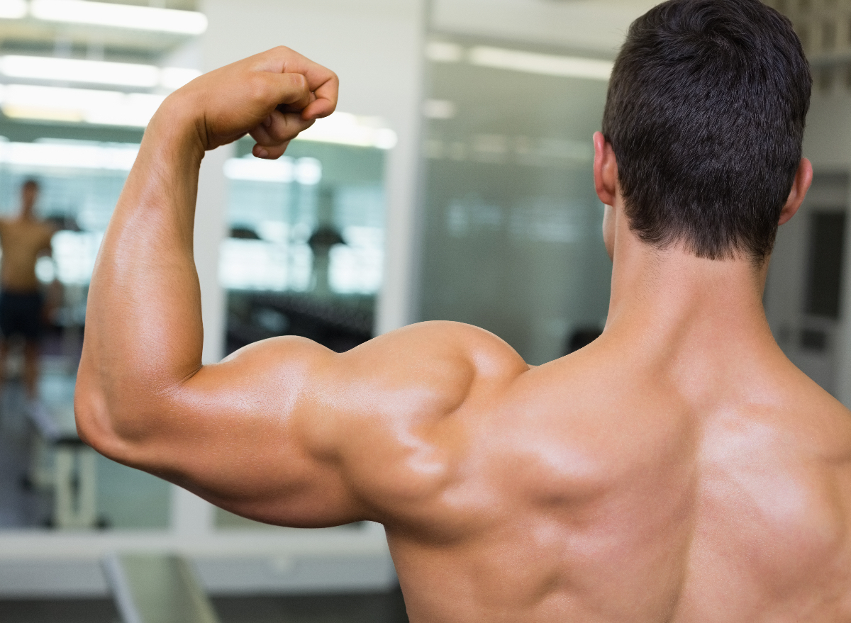 fit man flexes muscles at gym, demonstrates how to get fit like a superhero