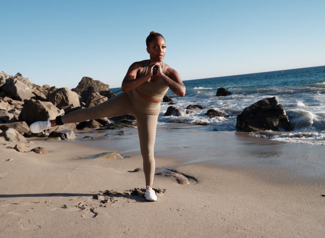 fit woman performing exercise on the beach