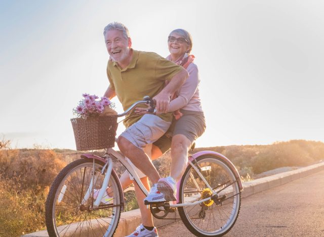 happy active senior couple bike riding