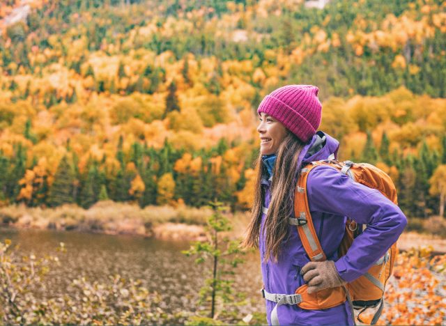 Une femme heureuse montre des habitudes de randonnée qui ralentissent le vieillissement en automne