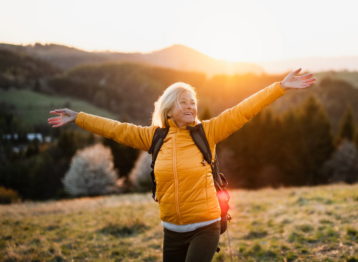happy senior woman exercising on hike to become a centenarian
