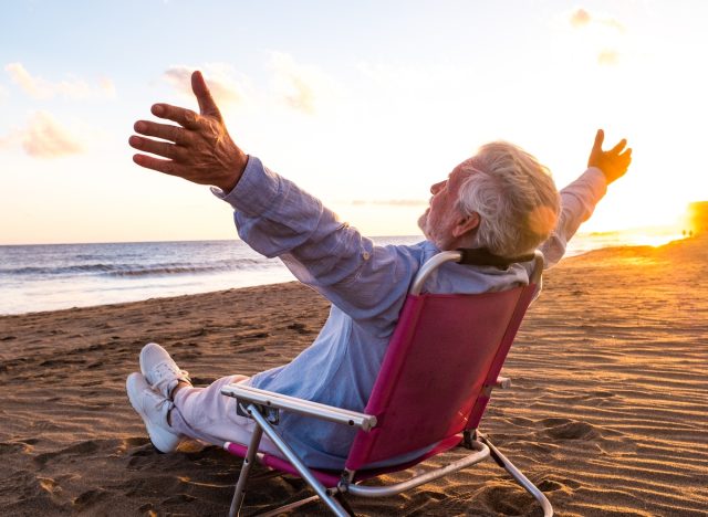 happy senior man on beach demonstrating the lifestyle habits that slow down aging