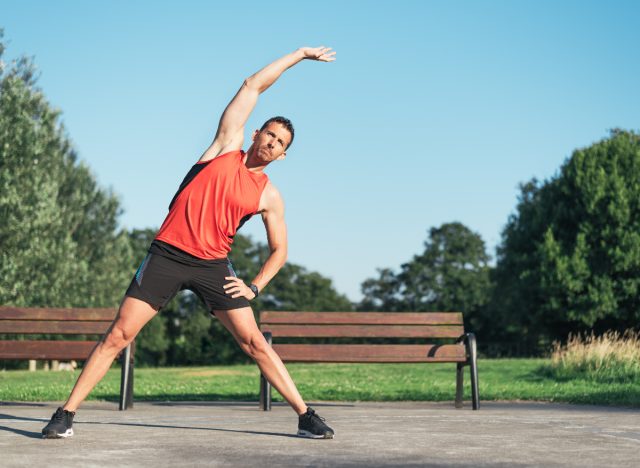 man in his 40s stretching outdoors