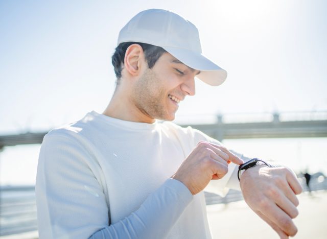 man checking fitness watch, easy trick to walk more each day