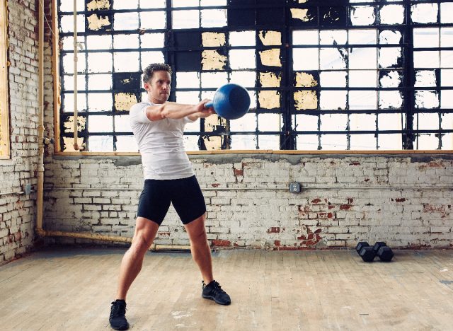 man doing kettlebell swings, workouts to maintain muscle tone in your 40s