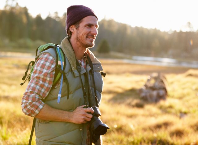 male photographer doing fall hike in countryside, hiking habits that slow aging