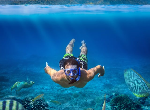snorkeling man demonstrating how incredibly healthy people stay fit while traveling