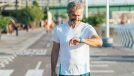man checking watch, demonstrating cardio tricks for burning more calories while walking