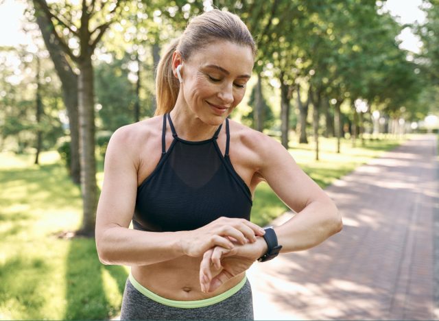 fit woman checking watch on walk, exercises for sagging jowls