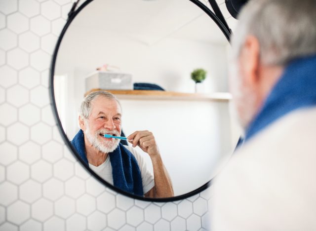 mature man brushing his teeth, healthy lifestyle habits to shrink a big belly for good