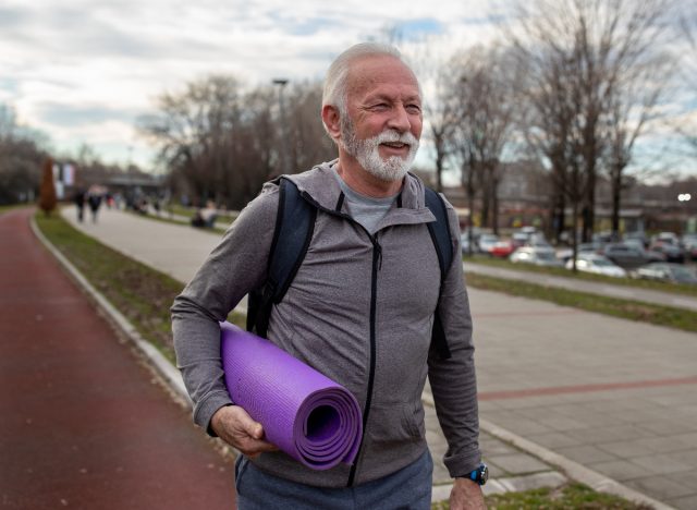 mature man walking to yoga class in order to shrink a big belly for good