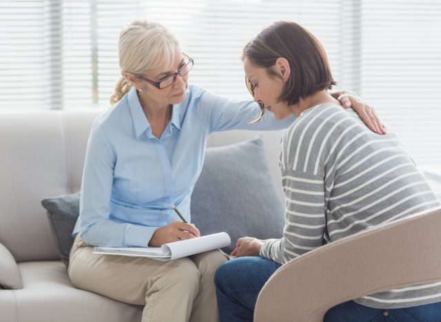 mature therapist helping female patient regarding how to deal with losing a parent