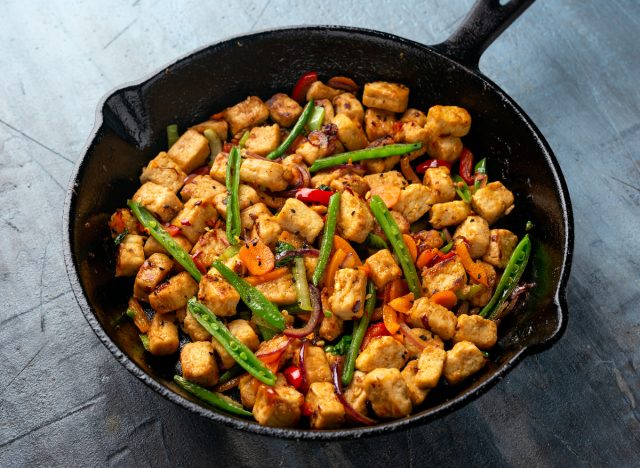 Mycoprotein and vegetables are fried in a cast iron pan