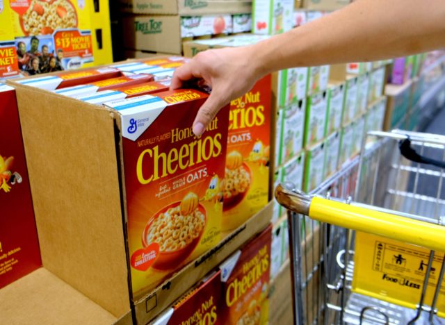 person taking honey nut cheerios at grocery store