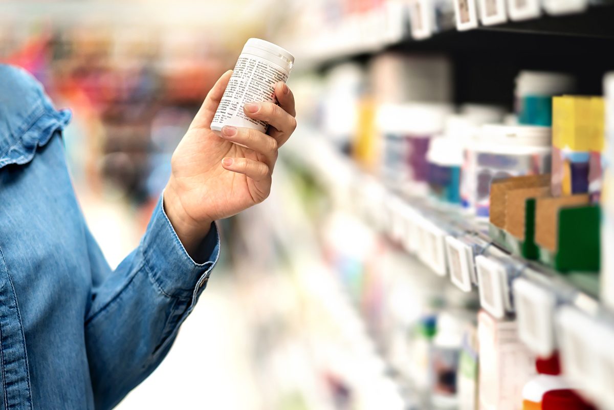 Customer,In,Pharmacy,Holding,Medicine,Bottle.,Woman,Reading,The,Label, pills