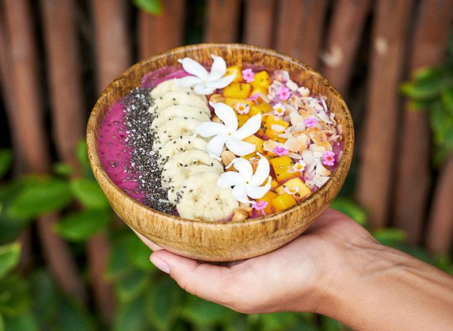 hand holding healthy tropical acai bowl on vacation