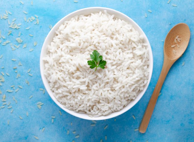 white rice in bowl with wooden spoon