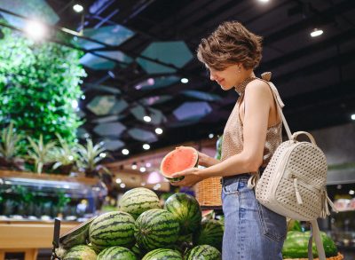 Woman choosing watermelon at the grocery store