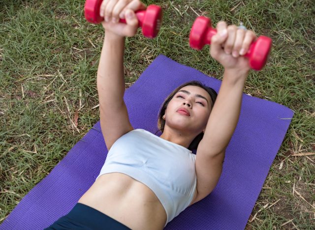 woman doing dumbbell chest press