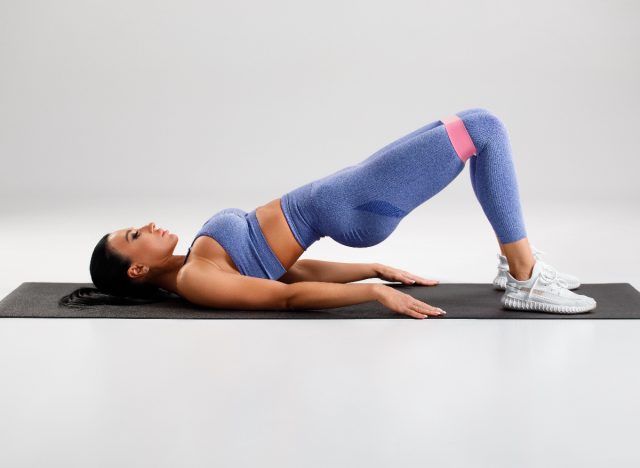 woman performing glute bridge with resistance band