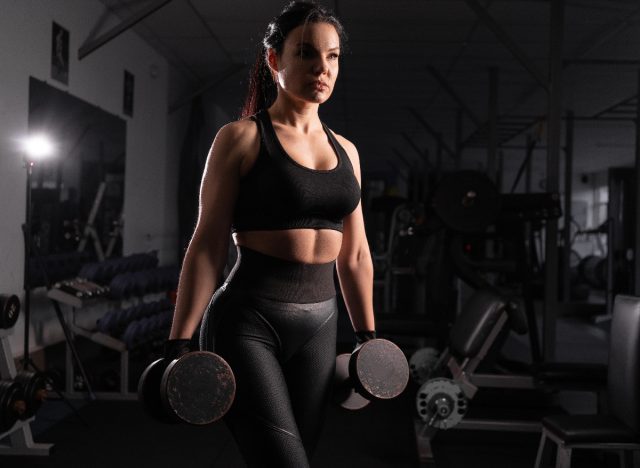 woman doing heavy dumbbell workout for a firmer butt