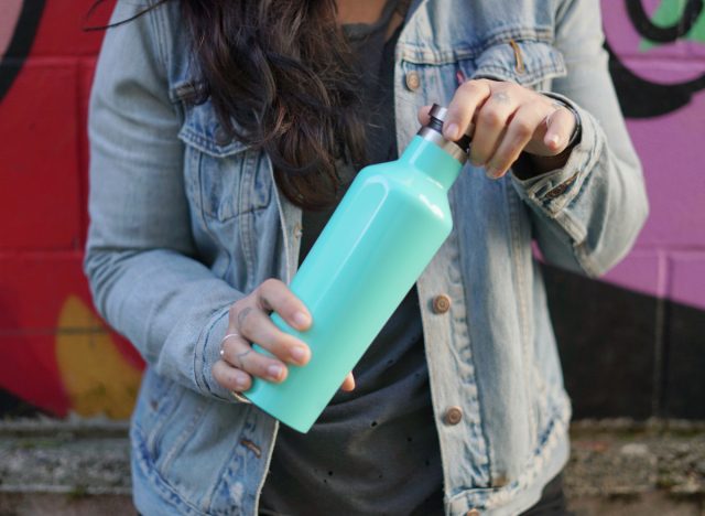 woman opening reusable water bottle