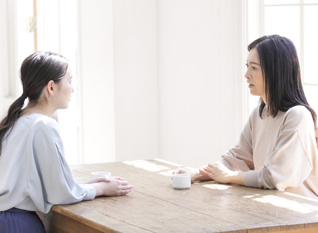 two women having serious conversation, talking at home