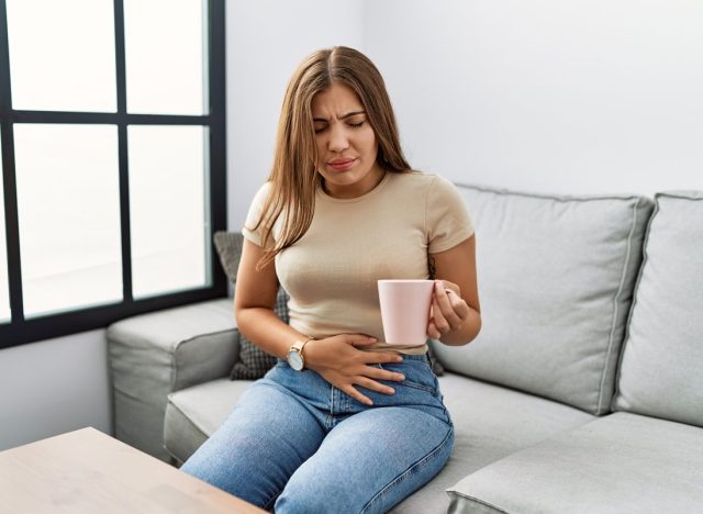 woman with upset stomach drinking tea