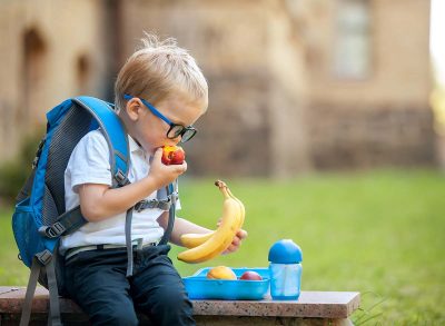 Kid snacking with backpack on