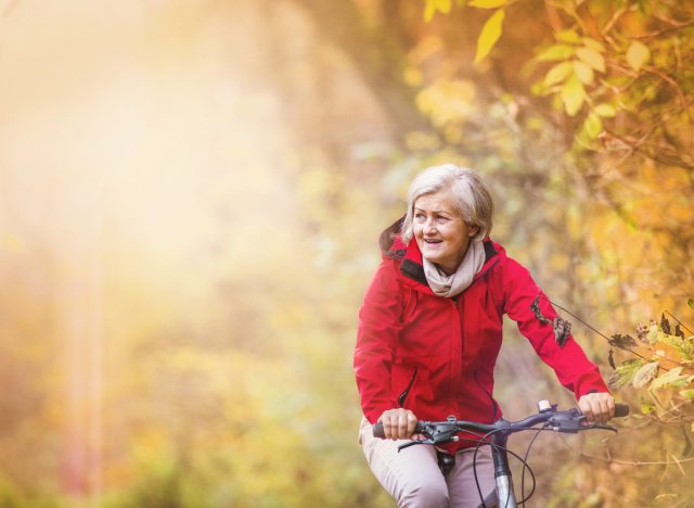 Aktive Seniorin beim Radfahren, die die Fahrradgewohnheiten demonstriert, die das Altern verlangsamen