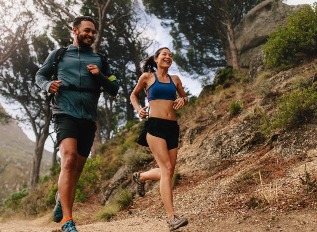 fit couple running trails outdoors, demonstrating running every day