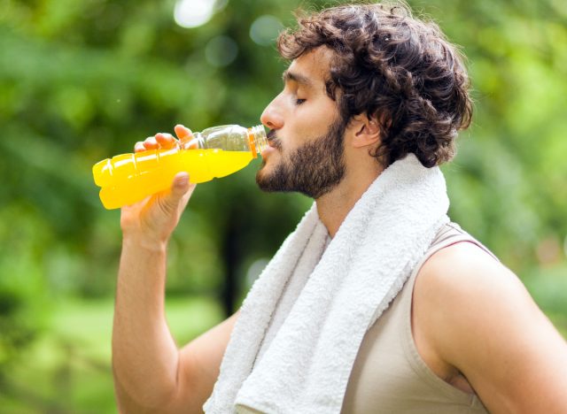 man over-drinking pre-workout supplement, demonstrating fitness habits that are rapidly aging your body