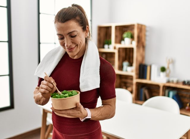 fitness woman eating salad, demonstrating eating after meals