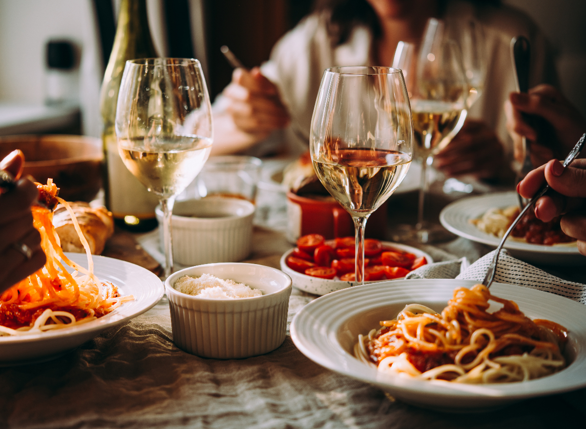 friends having pasta dinner with white wine