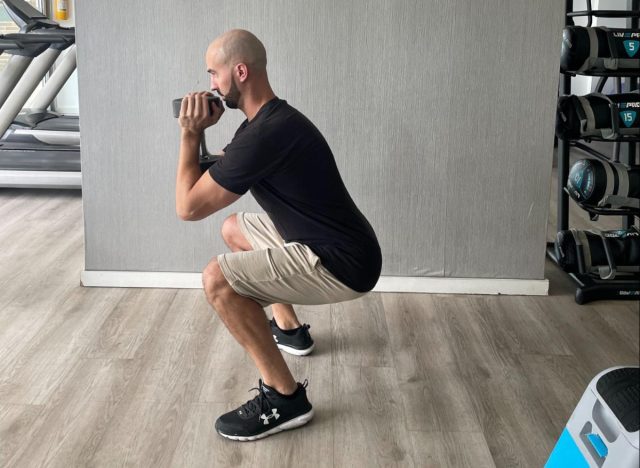 trainer performing goblet squat, workout to flatten your stomach