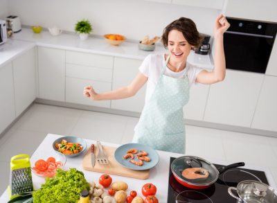 happy woman cooking in kitchen