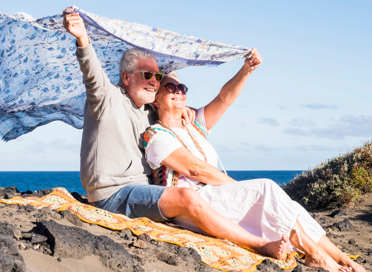 happy mature couple at the beach demonstrating tiny things that massively boost your health