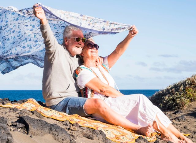 happy mature couple at the beach demonstrating tiny things that massively boost your health