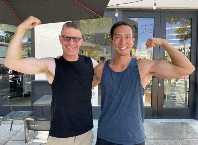 man posing with his personal trainer flexing muscles