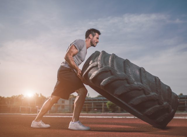 man performing intense tire workout, demonstrating when you work out too much