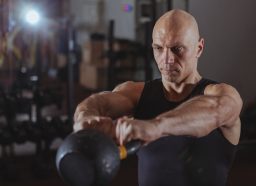 man demonstrating kettlebell workout to get rid of a big belly and slow aging